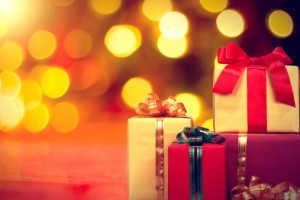 Christmas gift and baubles on defocused lights background